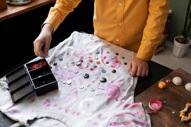 Niño pequeño haciendo proyecto artesanal de bricolaje con camiseta