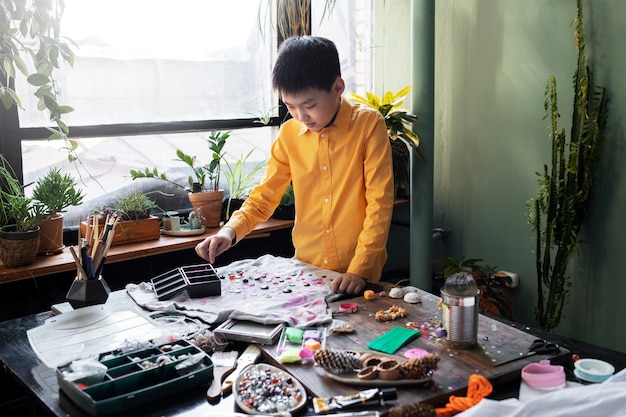 Niño pequeño haciendo proyecto artesanal de bricolaje con camiseta