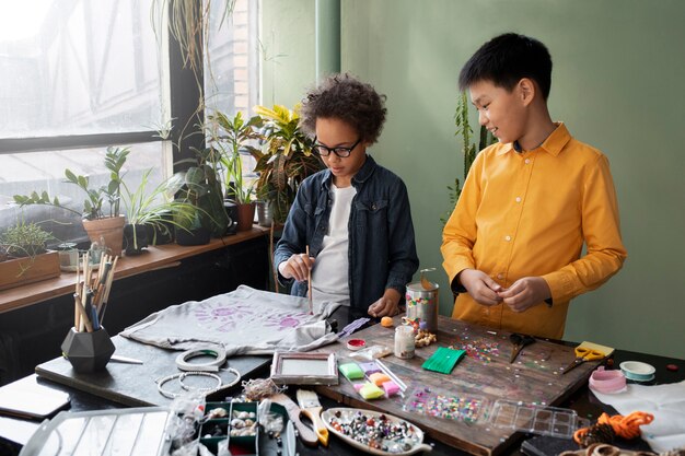 Niño pequeño haciendo un proyecto de bricolaje con materiales reciclados