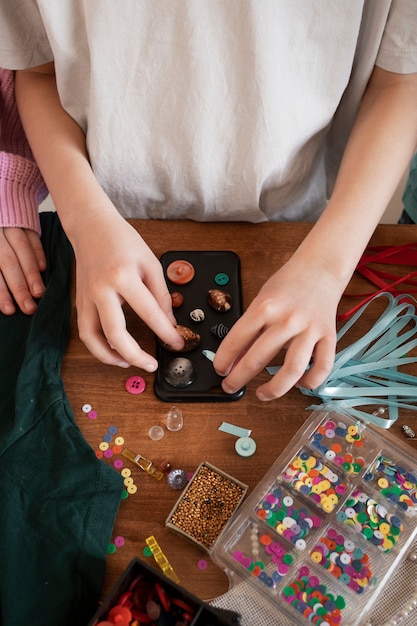 Niño pequeño haciendo un proyecto de bricolaje con materiales reciclados