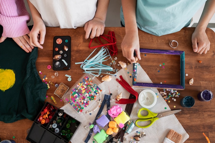 Foto gratuito niño pequeño haciendo un proyecto de bricolaje con materiales reciclados