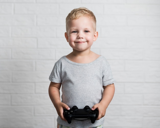 Niño pequeño con joystick mirando a la cámara
