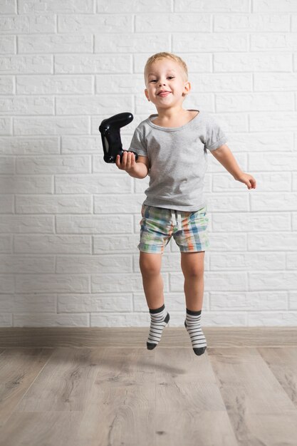 Niño pequeño con joystick y saltando