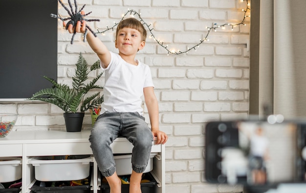 Foto gratuita niño pequeño jugando con araña