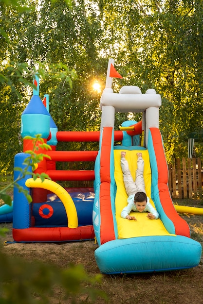 Niño pequeño jugando en la casa de rebote tiro completo