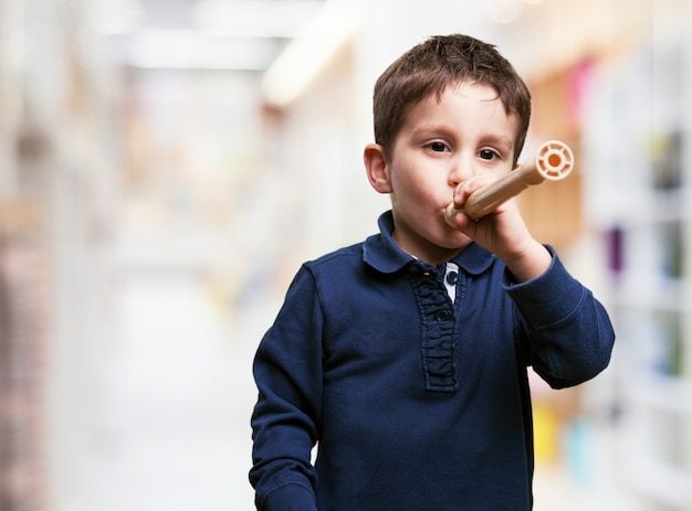 Foto gratuita niño pequeño jugando con una flauta