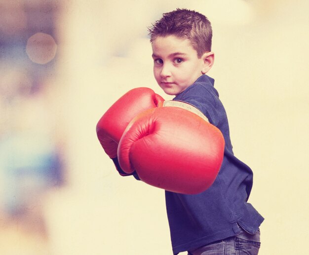 Niño pequeño jugando con guantes de boxeo