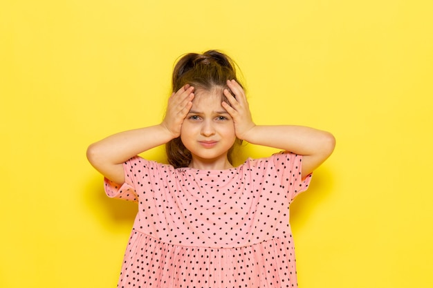 Un niño pequeño lindo vista frontal en vestido rosa posando con expresión estresada