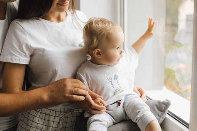 Un niño pequeño mira lo que está pasando afuera de la ventana.