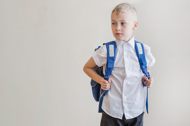 Niño pequeño con mochila en estudio