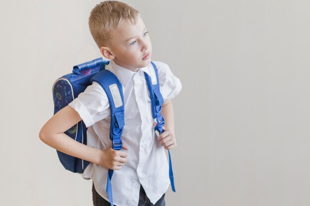 Niño pequeño con mochila en estudio