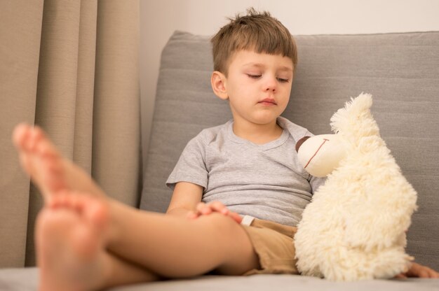 Niño pequeño con oso tedy en casa