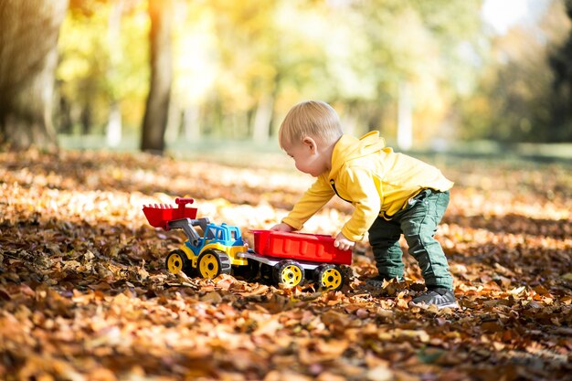 Niño pequeño en el parque de otoño