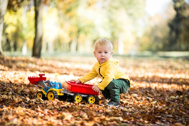 Niño pequeño en el parque de otoño