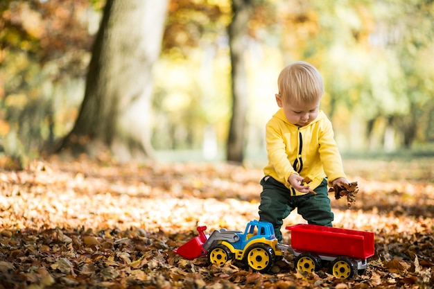 Niño pequeño en el parque de otoño