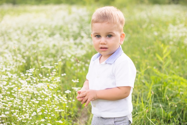 Niño pequeño de pie en el prado