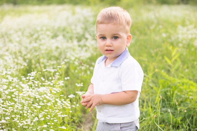 Niño pequeño de pie en el prado