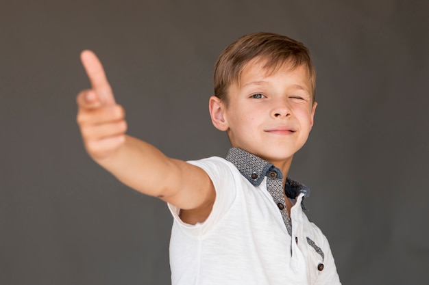 Niño pequeño que hace un arma con sus dedos