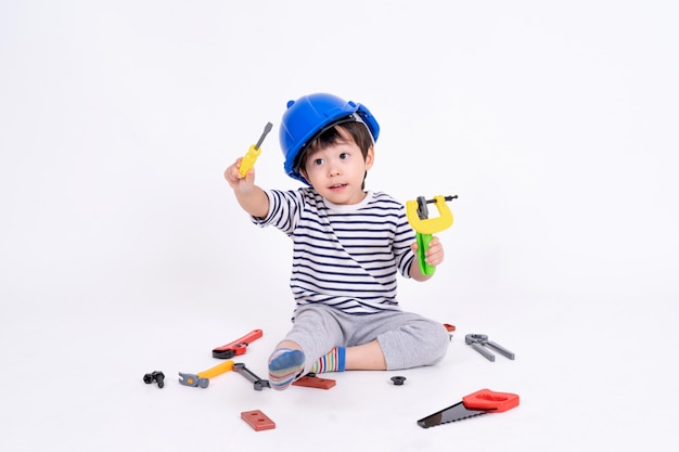 Niño pequeño que juega con el material de construcción en blanco