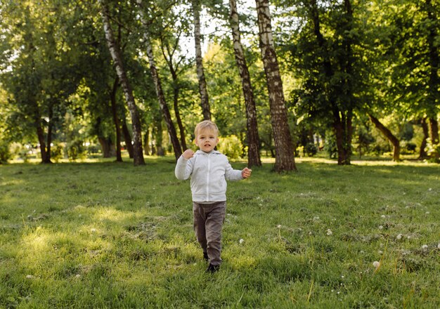 Niño pequeño que juega la pelota de fútbol al aire libre