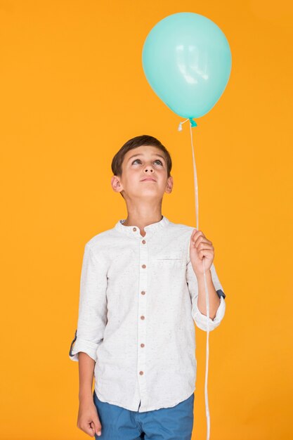 Niño pequeño que mira un globo azul