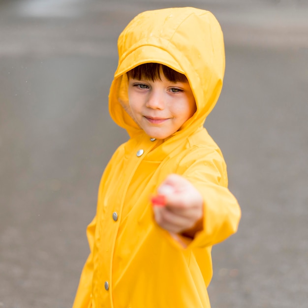 Foto gratuita niño pequeño que sostiene algo desenfocado en su mano