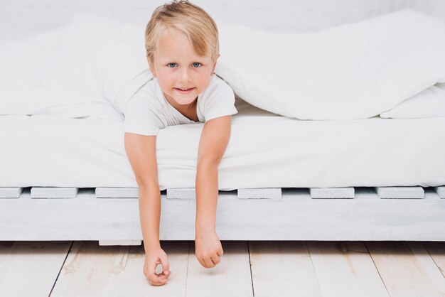 Niño pequeño quedándose en la cama