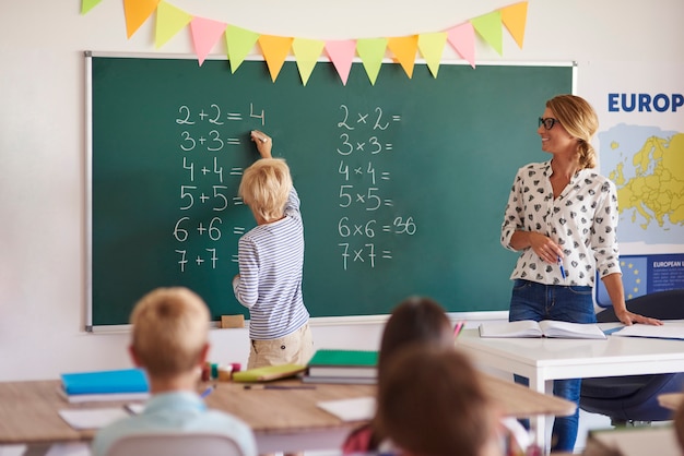 Foto gratuita el niño pequeño está resolviendo la tarea.