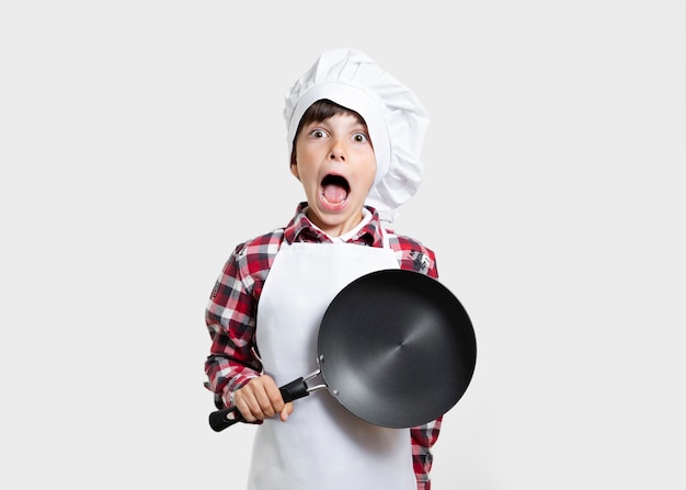 Foto gratuita niño pequeño con una sartén sorprendido