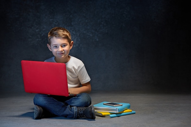 Foto gratuita niño pequeño sentado con laptop