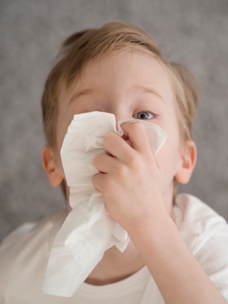 Niño pequeño sonarse la nariz