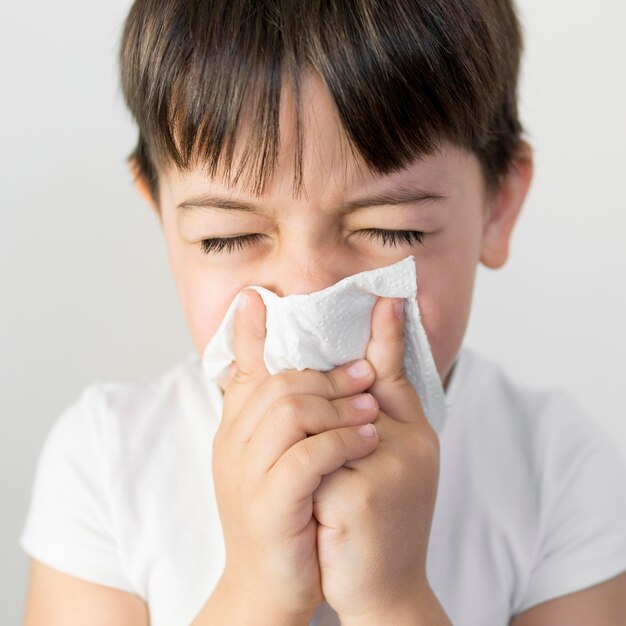 Niño pequeño sonarse la nariz