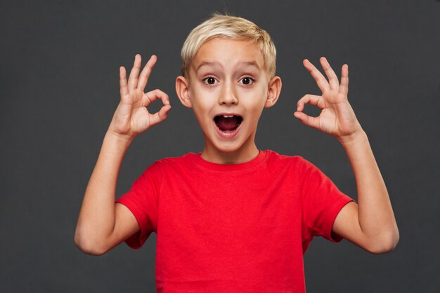 Niño pequeño sonriente que muestra gesto aceptable.