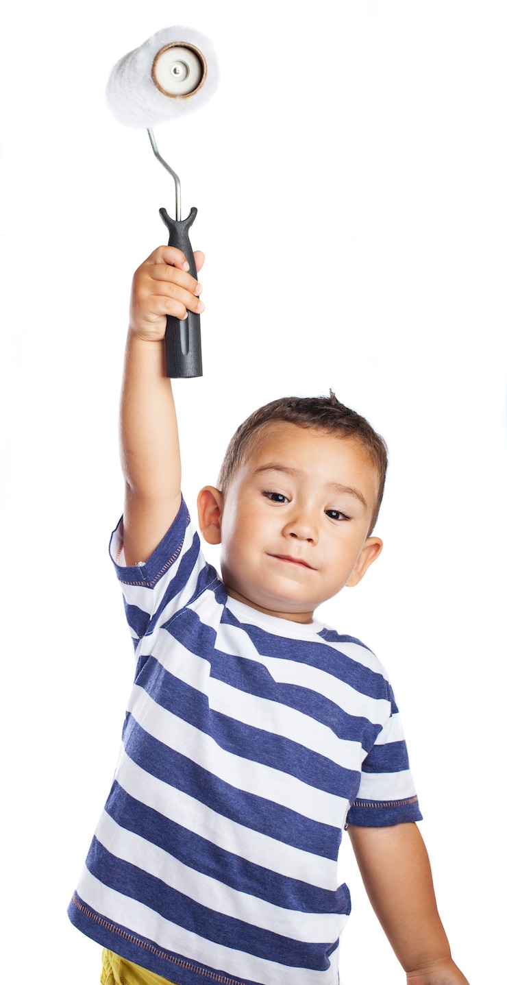 Foto gratuito niño pequeño sujetando en alto un rodillo de pintura