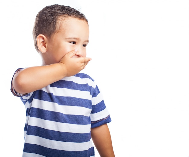 Foto gratuita niño pequeño tapándose la boca mientras se rie