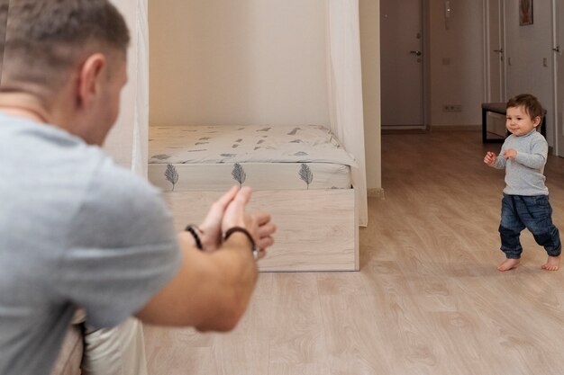 Niño pequeño de tiro completo caminando en casa