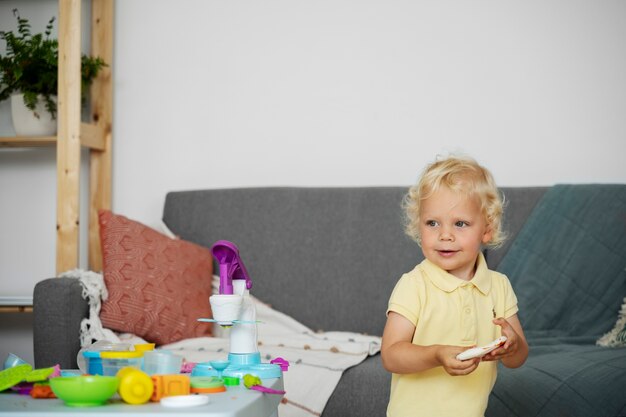 Niño pequeño de tiro medio con juguetes