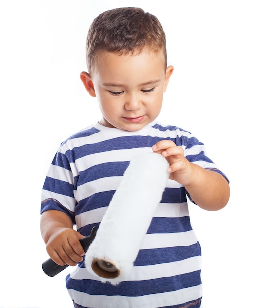 Foto gratuita niño pequeño tocando un rodillo de pintura