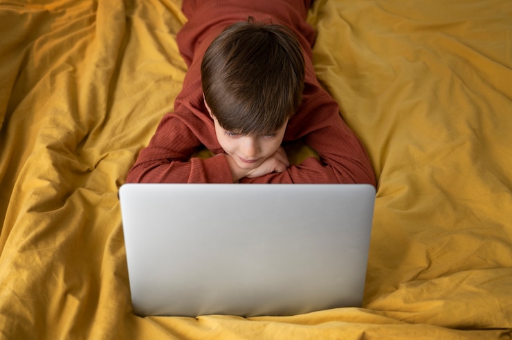 Foto gratuito niño pequeño viendo películas en la computadora portátil