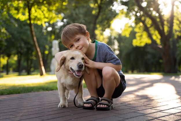 Niño y perro de tiro completo en el parque