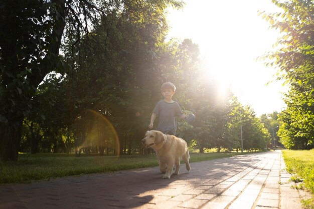Niño y perro de tiro completo en el parque