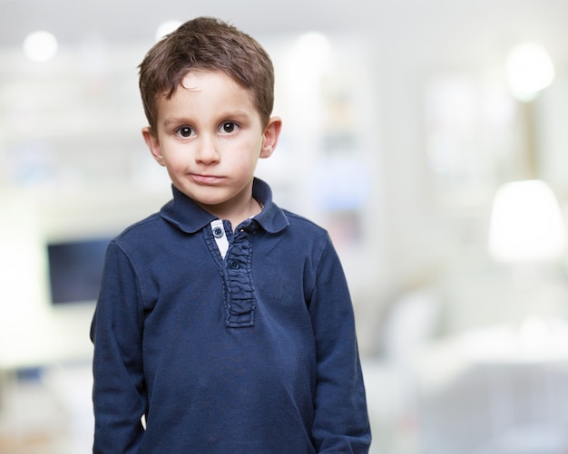 Foto gratuita niño de pie con cara seria