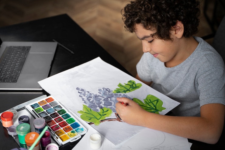 Foto gratuito niño pintando con acuarela