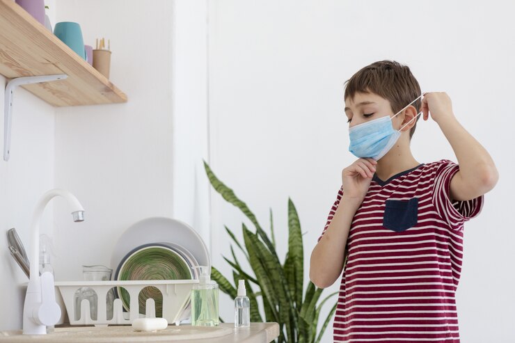 Foto gratuito niño poniéndose máscara médica