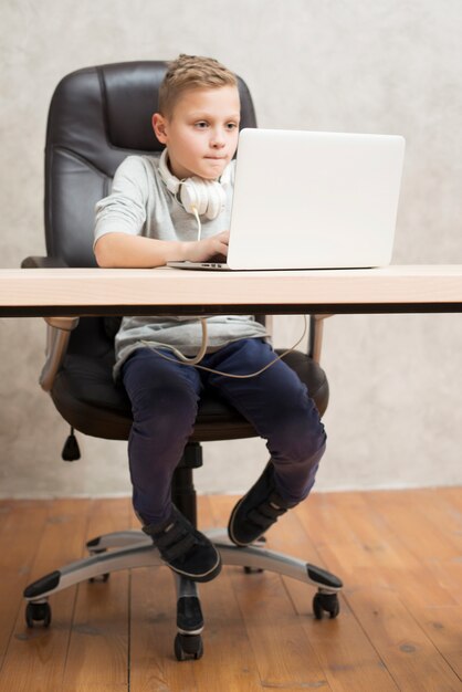 Niño con portátil en oficina