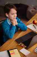 Foto gratuita un niño preadolescente usa una computadora portátil para hacer clases en línea