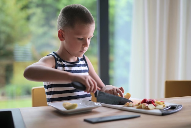 niño prepara fruta en la cocina