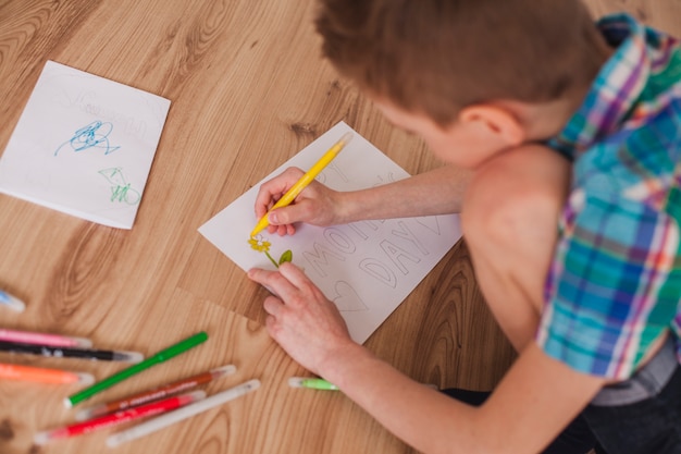 Foto gratuita niño preparando un bonito dibujo para su madre