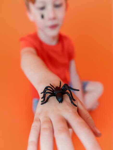 Niño de primer plano con araña de halloween en la mano