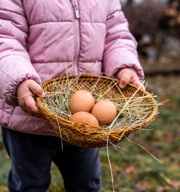 Niño de primer plano con canasta con huevos